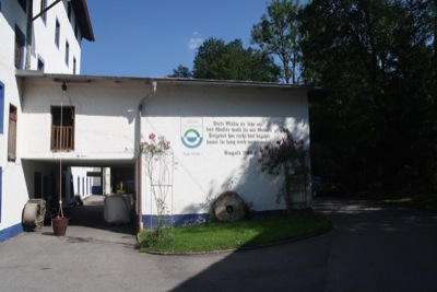 Die Einfahrt in die Mühle St. Johann, mit altem Mühlstein und Gedenkspruch zum Umbau im Jahre 2002.